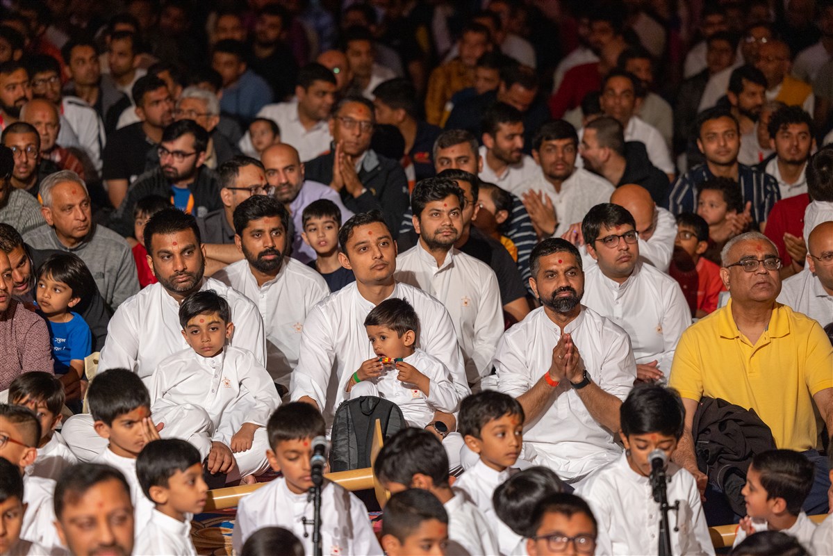 Families seated together at an evening assembly